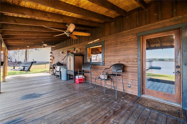 wooden deck with a water view and ceiling fan