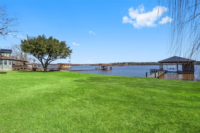 view of dock with a yard and a water view