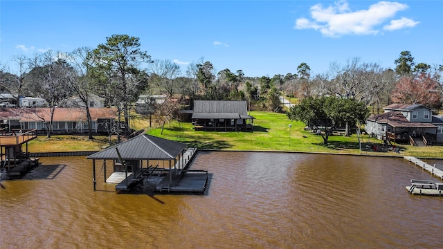 view of dock with a yard and a water view