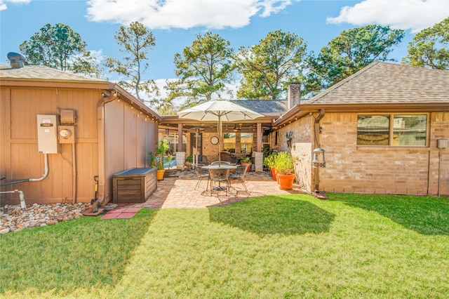 back of property featuring a patio area and a lawn