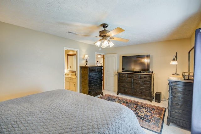 bedroom with ceiling fan, light colored carpet, and a textured ceiling