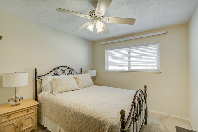 bedroom with ceiling fan, light colored carpet, and a textured ceiling