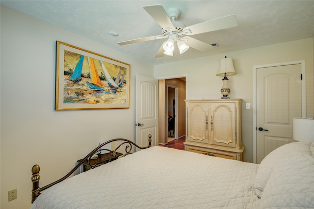 bedroom with ceiling fan and a textured ceiling