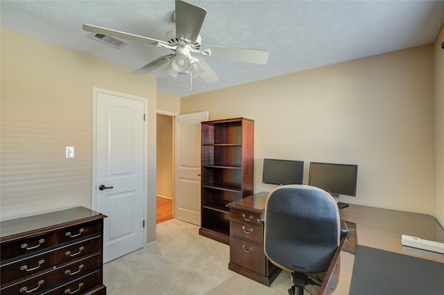 carpeted office featuring a textured ceiling and ceiling fan