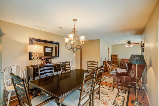 dining room featuring hardwood / wood-style floors and ceiling fan with notable chandelier