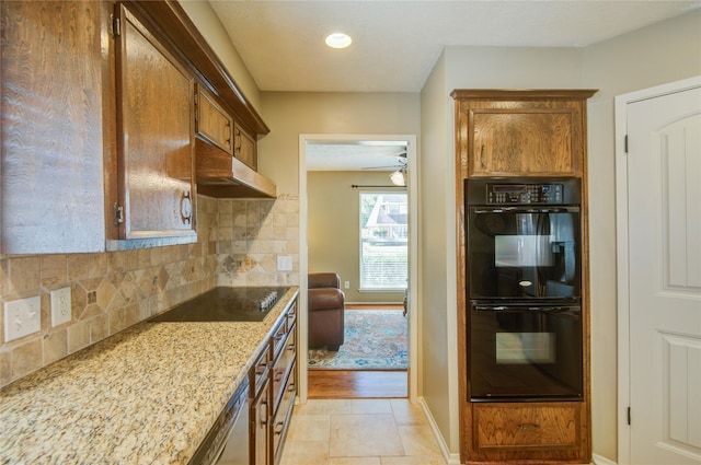 kitchen with light tile patterned floors, ceiling fan, backsplash, light stone countertops, and black appliances