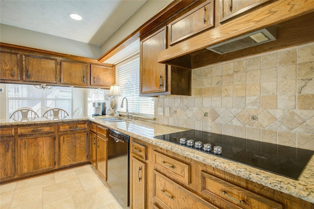 kitchen featuring light stone countertops, sink, decorative backsplash, and black appliances