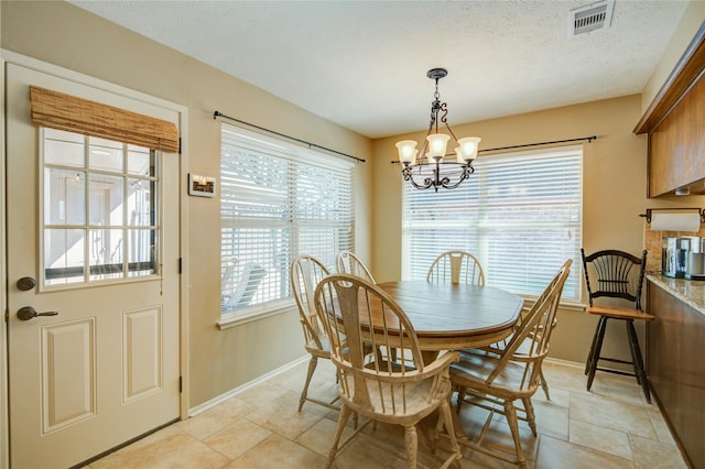 dining area featuring a notable chandelier and a textured ceiling