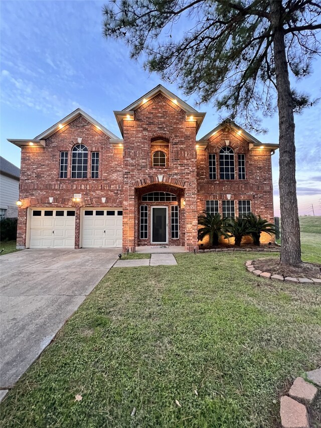 view of property featuring a garage and a lawn