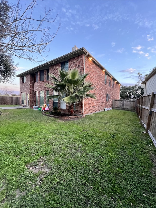 property exterior at dusk with a lawn