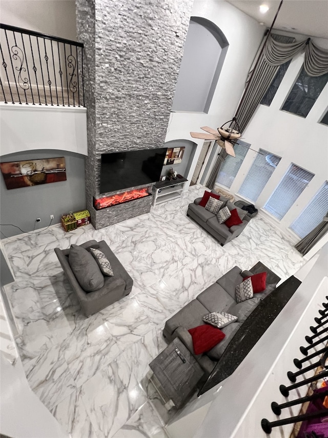 living room featuring a towering ceiling and a stone fireplace