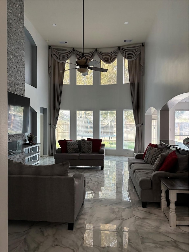 living room with a towering ceiling and ceiling fan