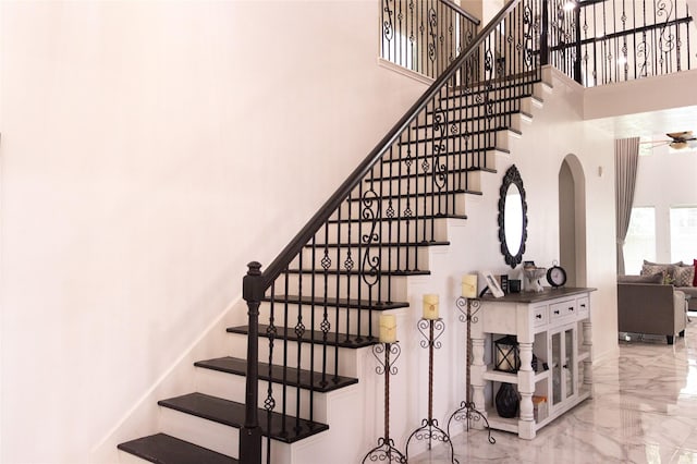 10722 Trail Ridge Dr, Houston, TX 77064 - staircase featuring marble tiled flooring, a high ceiling, arched walkways, and a ceiling fan