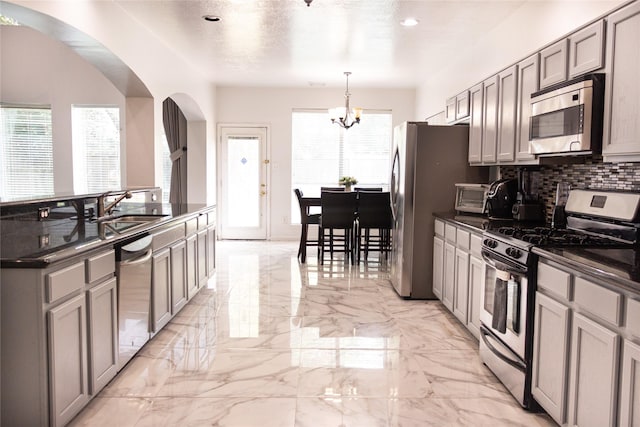 10722 Trail Ridge Dr, Houston, TX 77064 - kitchen featuring stainless steel appliances, dark countertops, a sink, arched walkways, and recessed lighting