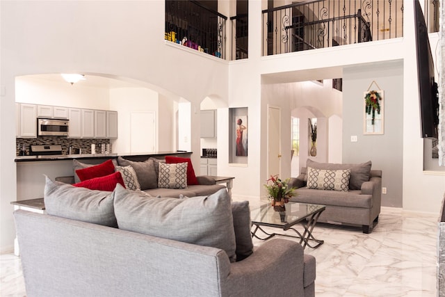 10722 Trail Ridge Dr, Houston, TX 77064 - living area with arched walkways, light marble finish flooring, a towering ceiling, and baseboards
