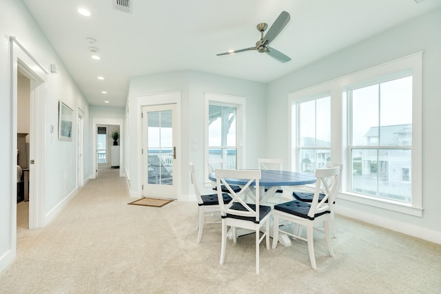 carpeted dining space featuring ceiling fan