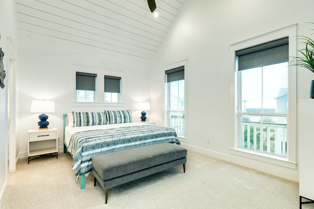 carpeted bedroom with vaulted ceiling and multiple windows