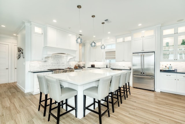 kitchen featuring pendant lighting, white cabinets, a center island, and stainless steel built in fridge