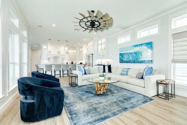 living room featuring crown molding and plenty of natural light