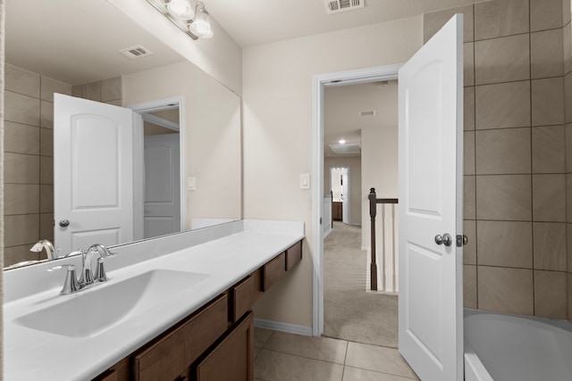 bathroom with tile patterned floors, vanity, and tile walls