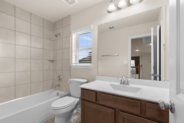 full bathroom featuring vanity, tiled shower / bath combo, and toilet