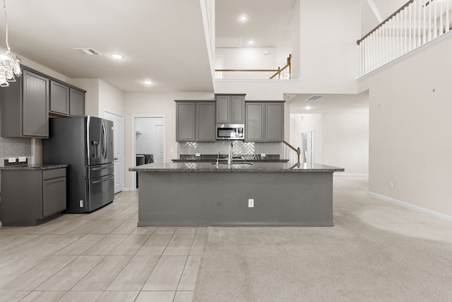 kitchen with gray cabinetry, sink, an island with sink, and appliances with stainless steel finishes