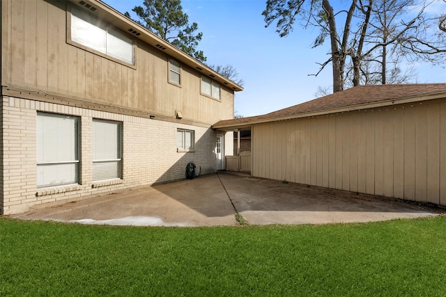 back of property with a patio area and a lawn