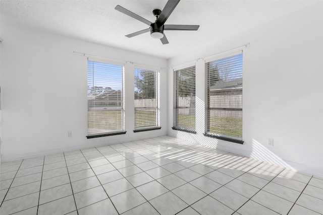 spare room with a textured ceiling, a wealth of natural light, and ceiling fan