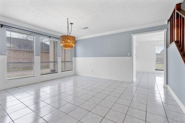 unfurnished room with crown molding, light tile patterned floors, and a textured ceiling