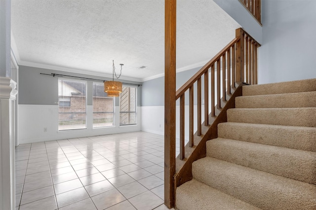 staircase featuring crown molding, tile patterned floors, and a textured ceiling