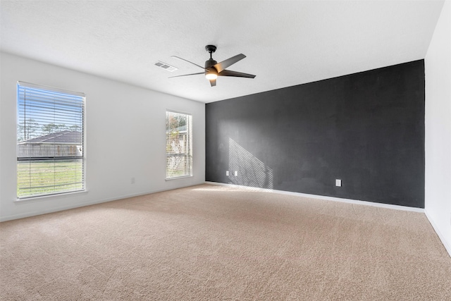 carpeted spare room with a textured ceiling and ceiling fan