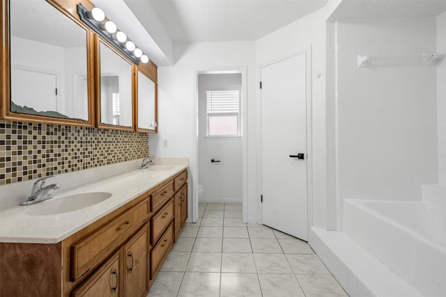 bathroom with vanity, decorative backsplash, and toilet