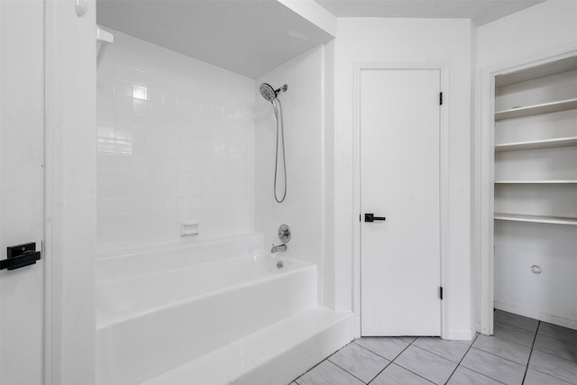 bathroom with tiled shower / bath and tile patterned flooring