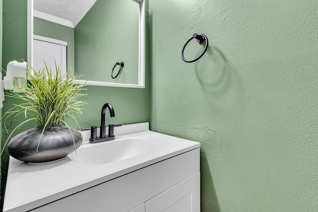 bathroom with vanity, crown molding, and a textured ceiling