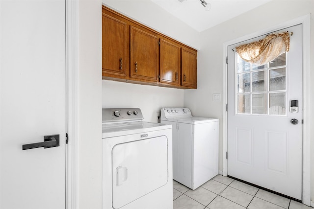 laundry area featuring light tile patterned floors, cabinets, and washing machine and clothes dryer