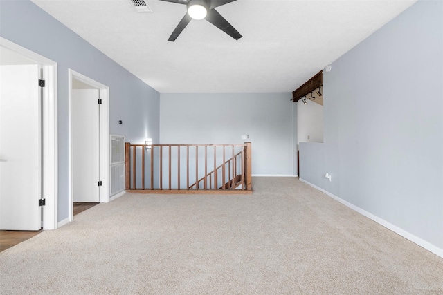 carpeted spare room featuring ceiling fan