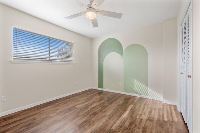 empty room with ceiling fan and wood-type flooring