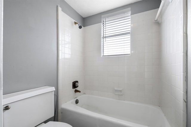 bathroom featuring tiled shower / bath and toilet