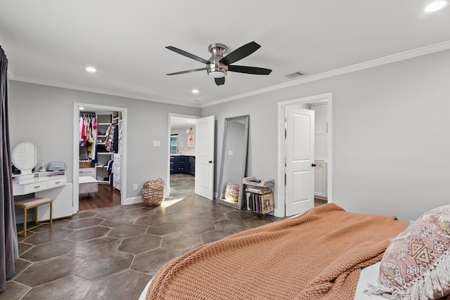 bedroom with crown molding, a walk in closet, ensuite bath, and a closet