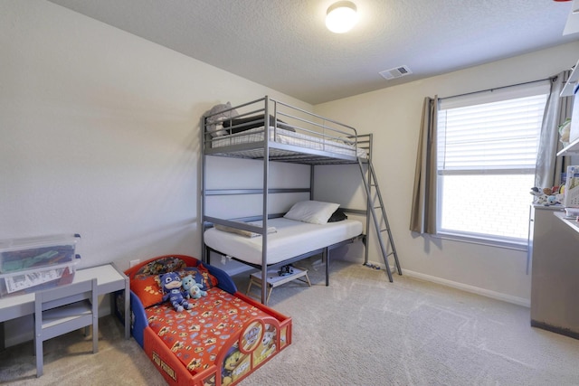 carpeted bedroom with a textured ceiling, visible vents, and baseboards