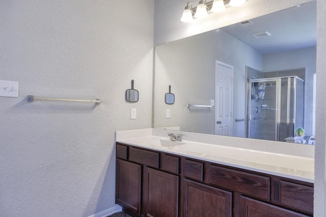 full bath featuring a shower stall, visible vents, and vanity