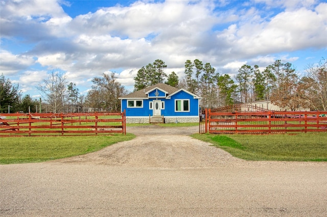 view of front of home with a front lawn and a rural view