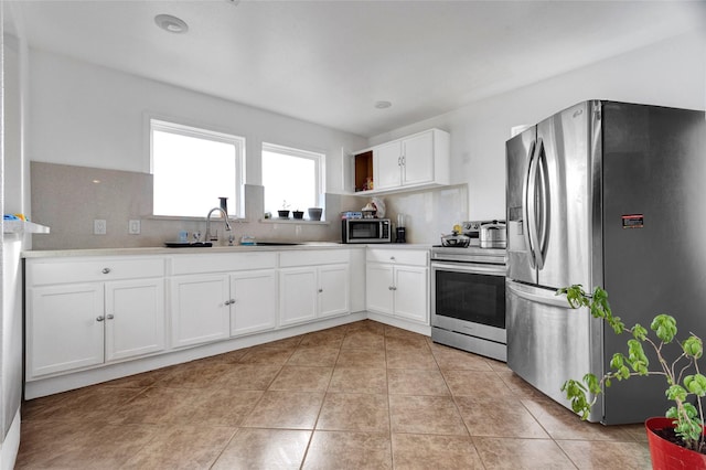 kitchen with sink, light tile patterned floors, white cabinets, stainless steel appliances, and backsplash