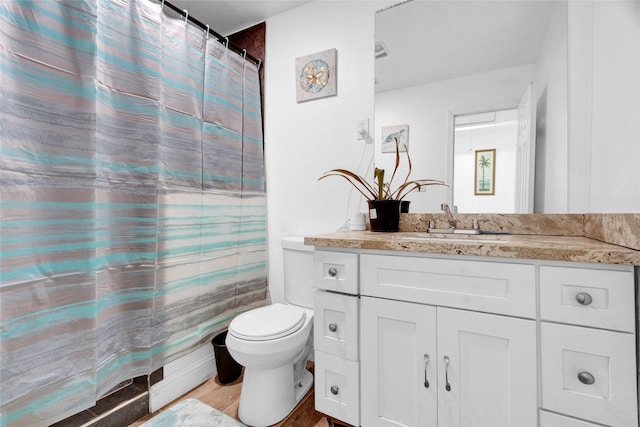 bathroom with hardwood / wood-style flooring, vanity, a shower with shower curtain, and toilet