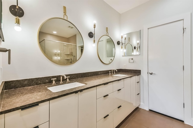 bathroom featuring tile patterned flooring, vanity, and a shower with shower door