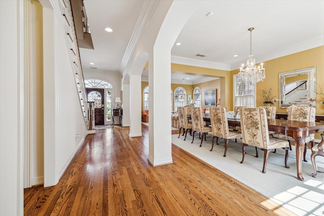 interior space featuring wood-type flooring, crown molding, and a chandelier