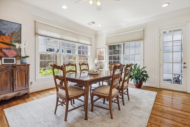 dining room with ornamental molding, ceiling fan, and light wood-type flooring