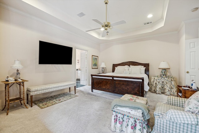 bedroom with ornamental molding, light carpet, ceiling fan, and a tray ceiling