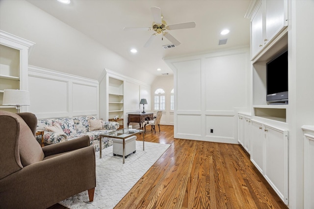 living room featuring built in features, dark hardwood / wood-style floors, and ceiling fan