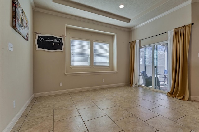 spare room with ornamental molding, a tray ceiling, a textured ceiling, and light tile patterned floors